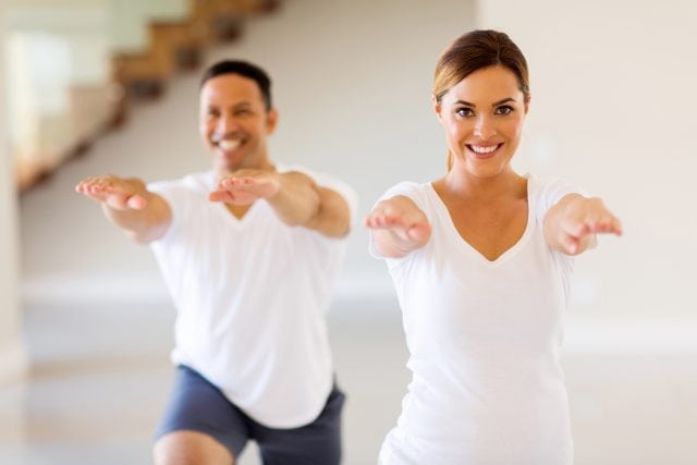 happy young woman exercising with boyfriend