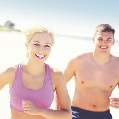 A picture of a young couple jogging along the beach A picture of a young couple jogging along the beach
